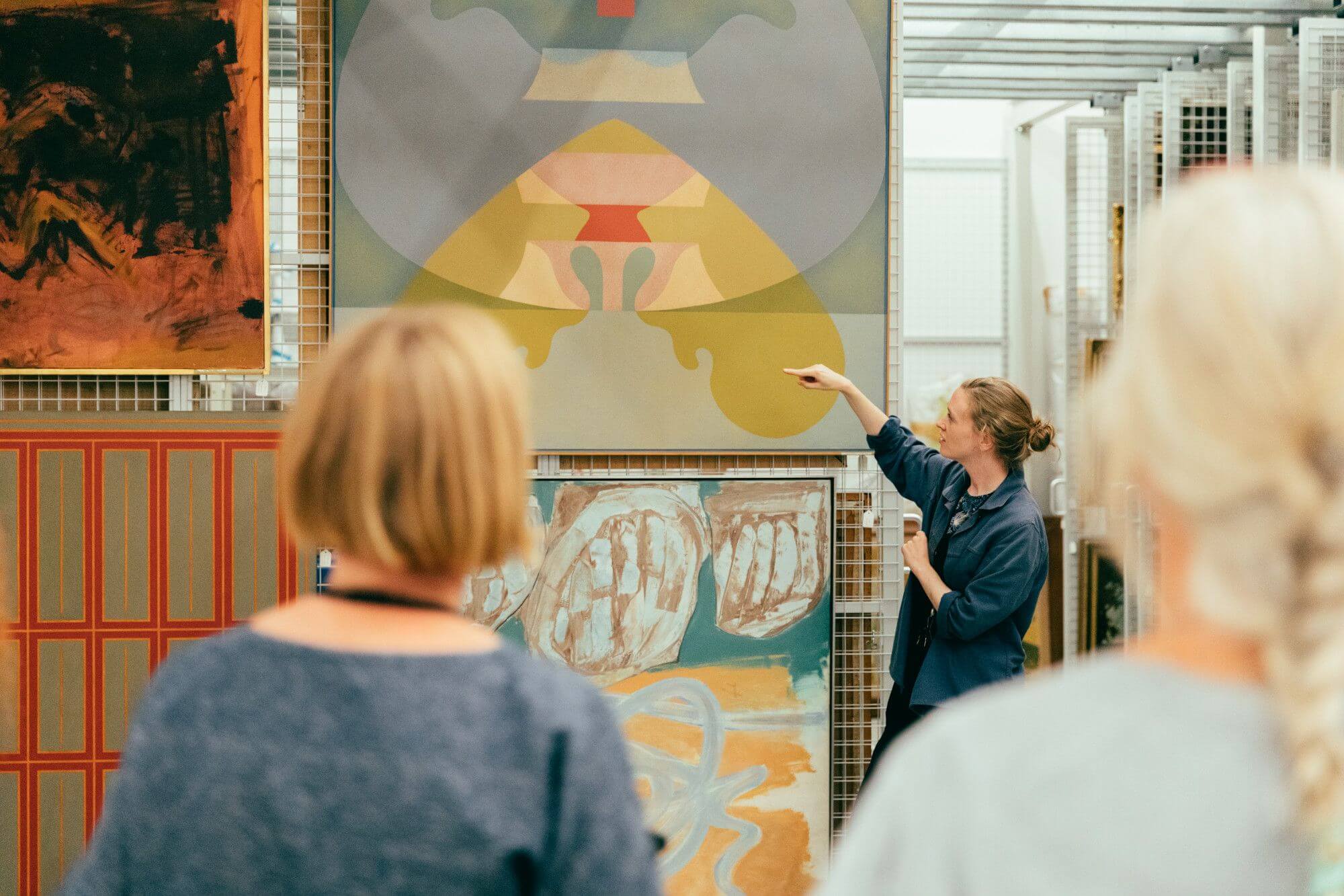 People looking at paintings hanging on a large metal rack in Towner's Art Store